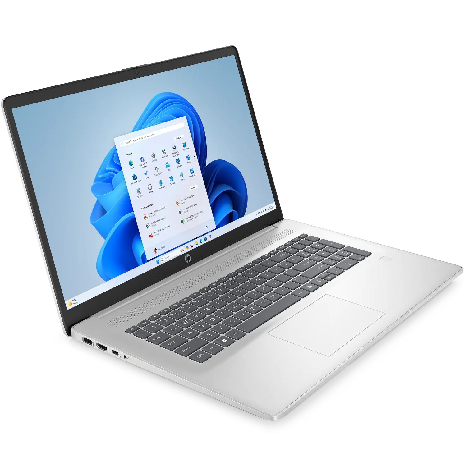 Angled front-right perspective view of the open natural silver HP AI 17-cn5xxx laptop showcasing its 17.3-inch HD display running Windows 11 with the Start Menu displayed, slim side bezels with top camera shutter, matching silver palm rest with a dedicated numeric keypad, fingerprint reader, and side I/O ports.