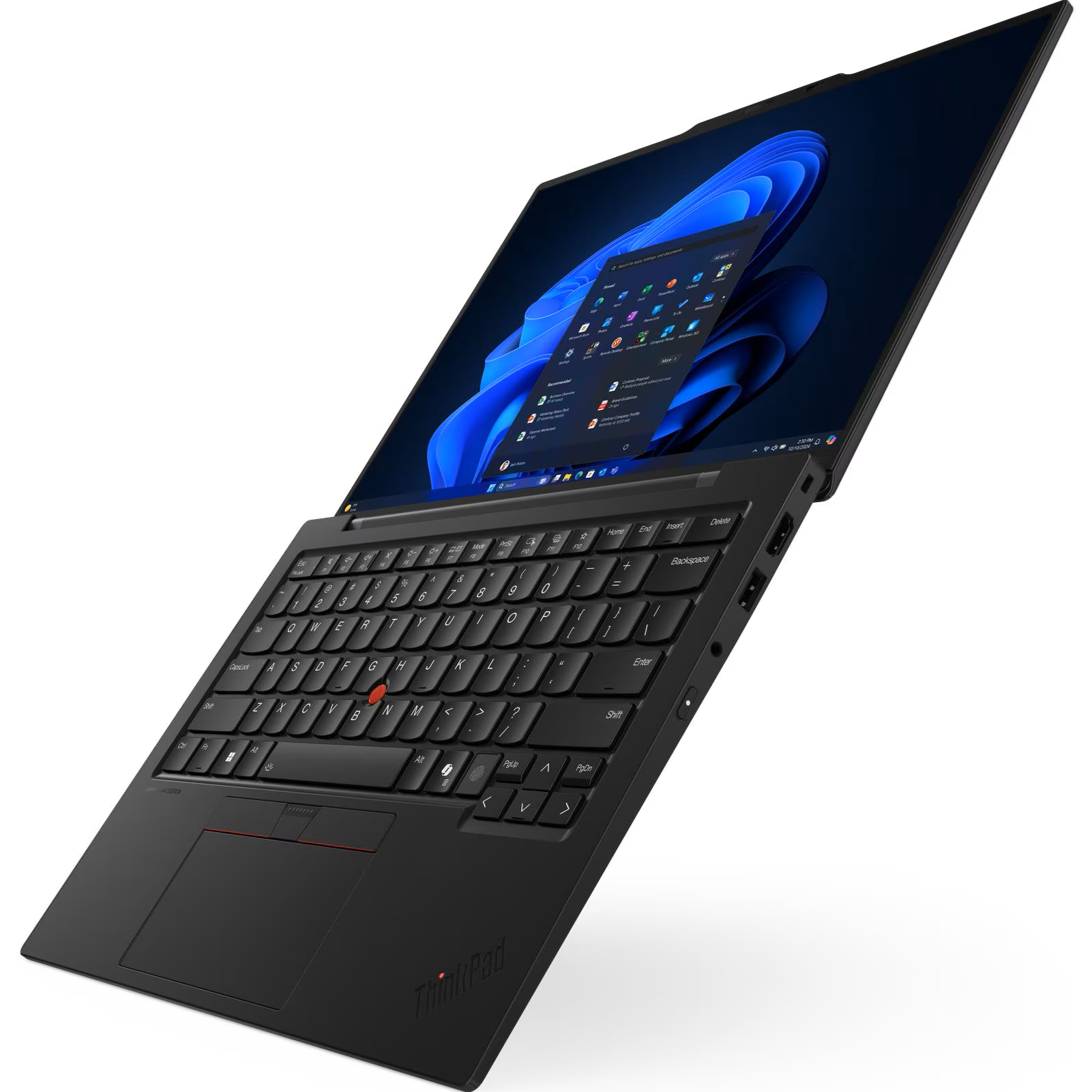 High-angle front-left perspective of the open Lenovo ThinkPad X1 Carbon Gen 13 AURA Edition displaying its red TrackPoint nub, touchpad with discrete buttons, compact keyboard, and Windows 11 desktop on the 14-inch OLED display.