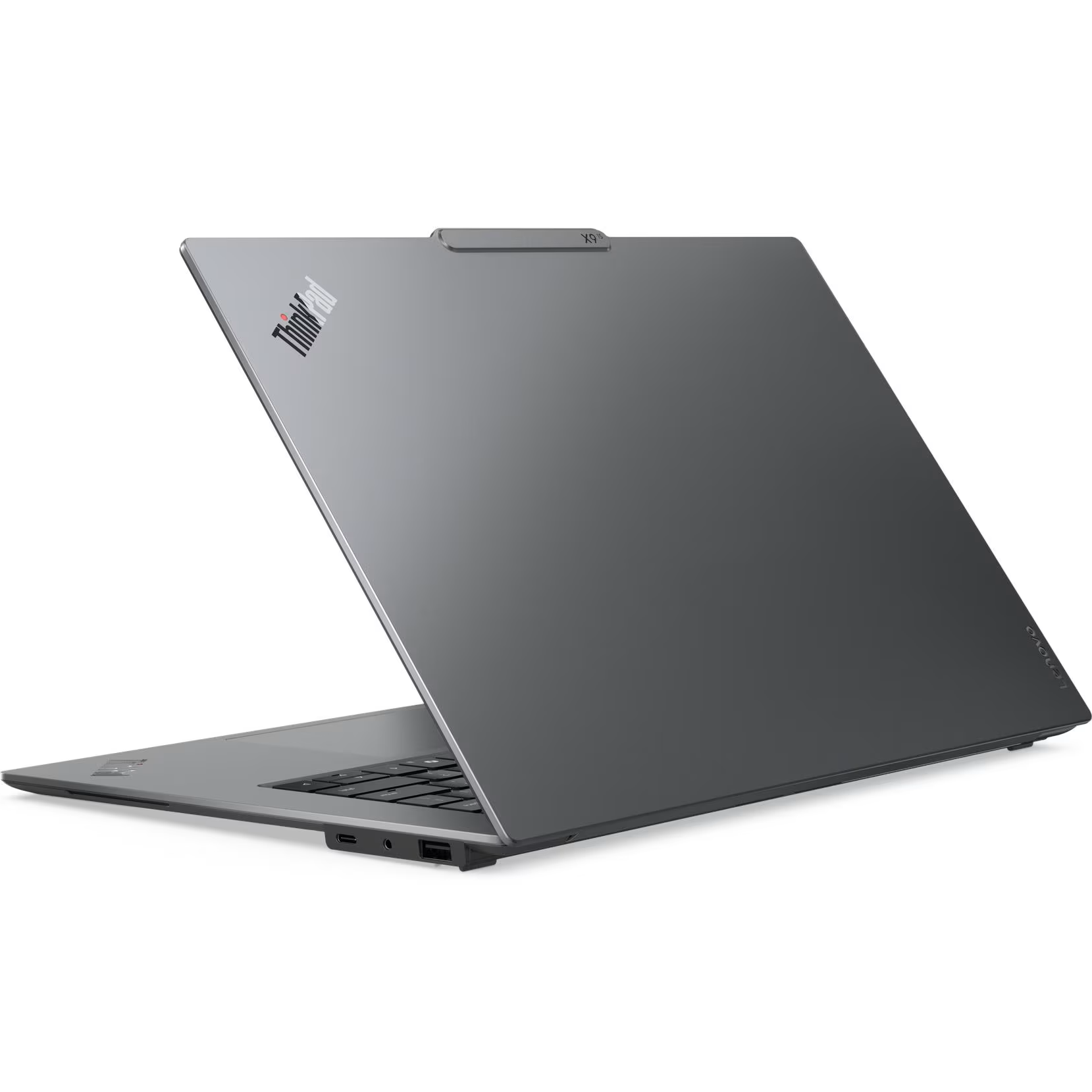 Rear-left angled view of the open Lenovo ThinkPad X9-15 Gen 1 AURA Edition highlighting the metallic lid with ThinkPad logo, top Communications Bar notch marked X9-15, and Lenovo corner branding.